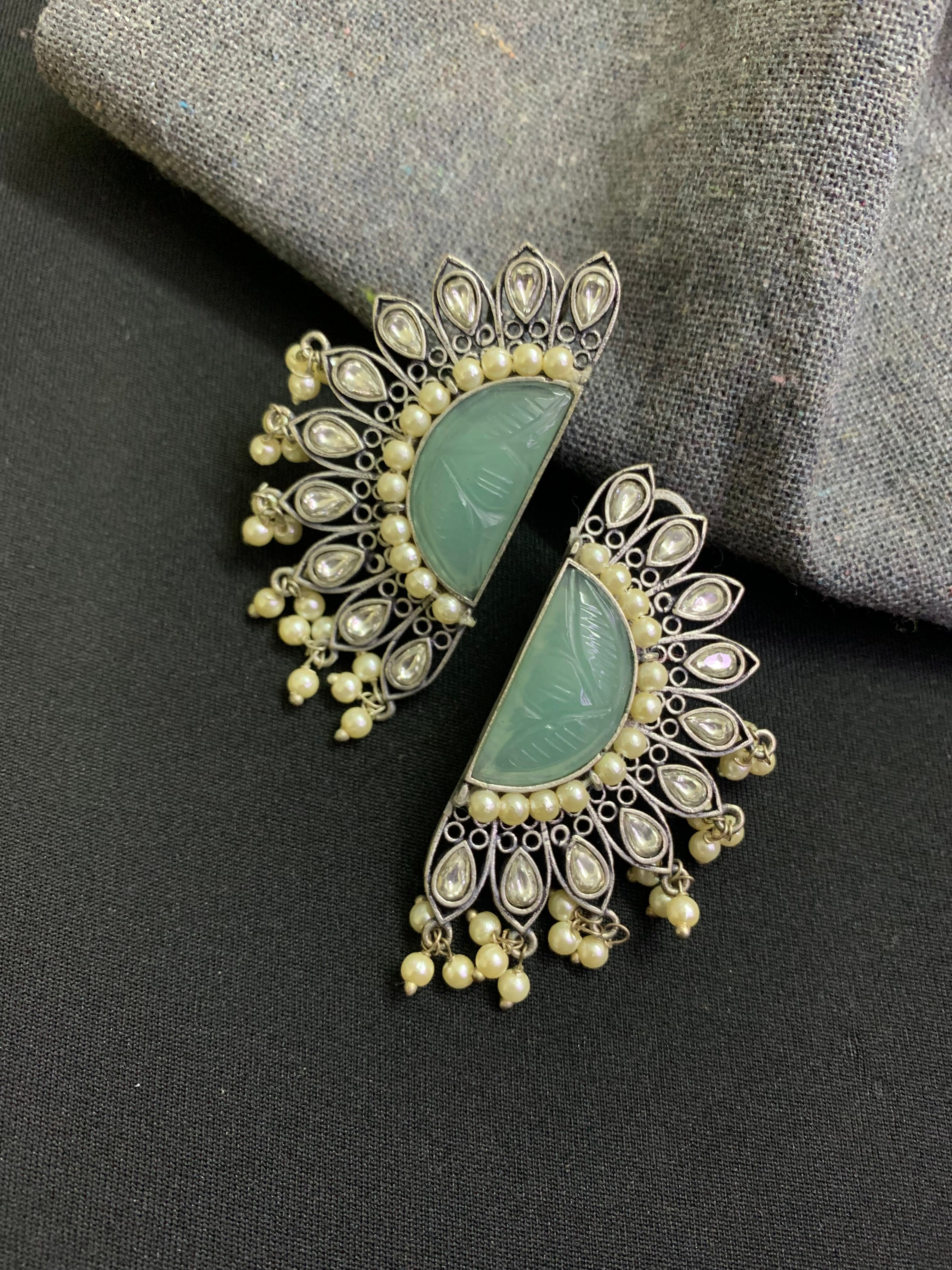 OZEL OXIDISED SILVER PLATED WITH CARVED MINT GREEN STONE STUDED WITH PEARLS AND KUNDAN EAR STUDS